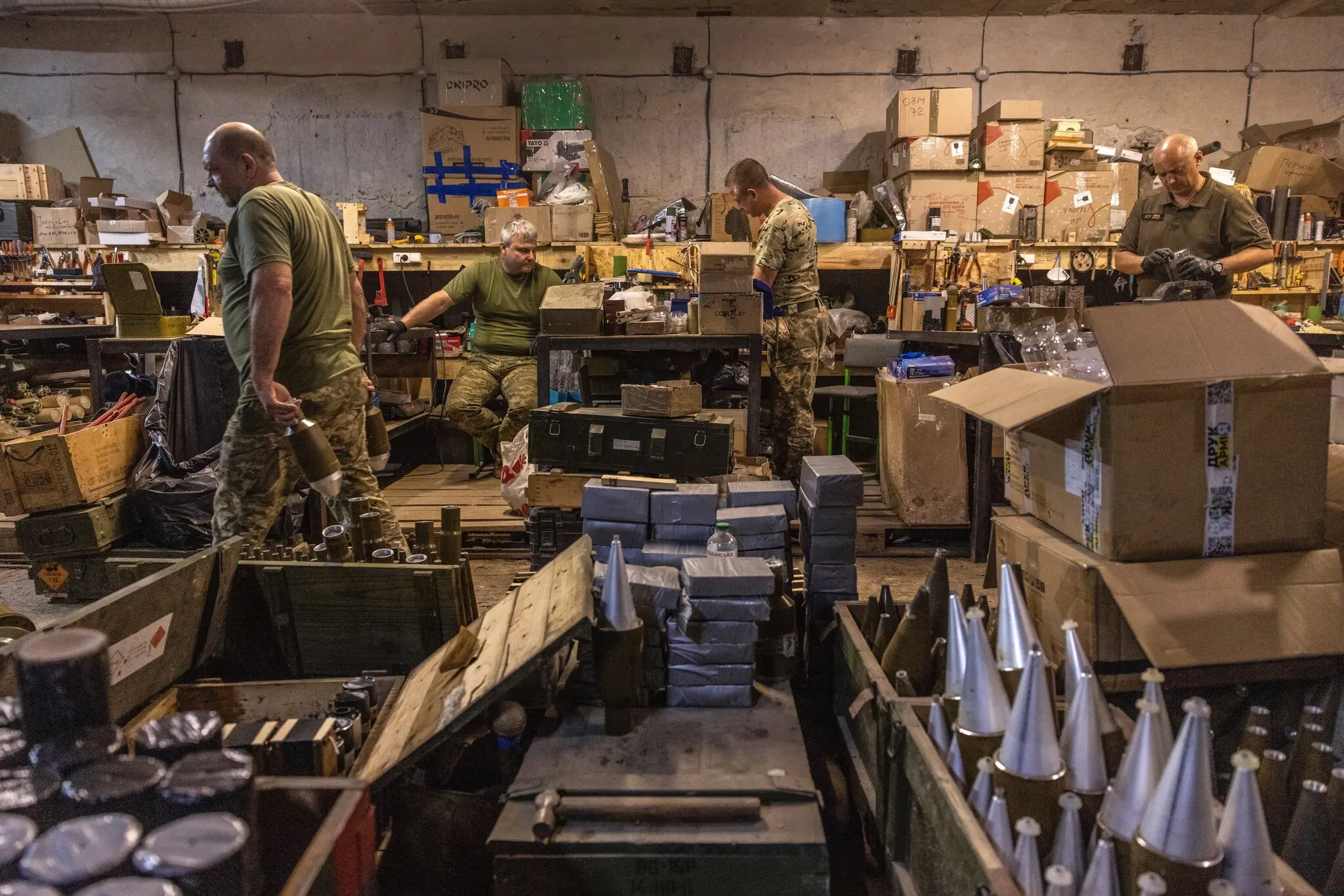 Юзик (ліворуч), майстер цеху, у цеху боєприпасів, який значною мірою переобладнав звичайні боєприпаси зі старих складів для боротьби з безпілотниками. 